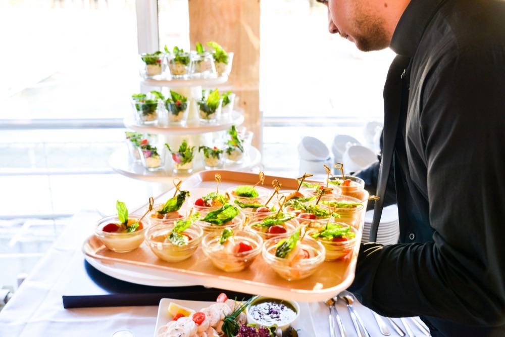 A waiter carrying a tray of starters