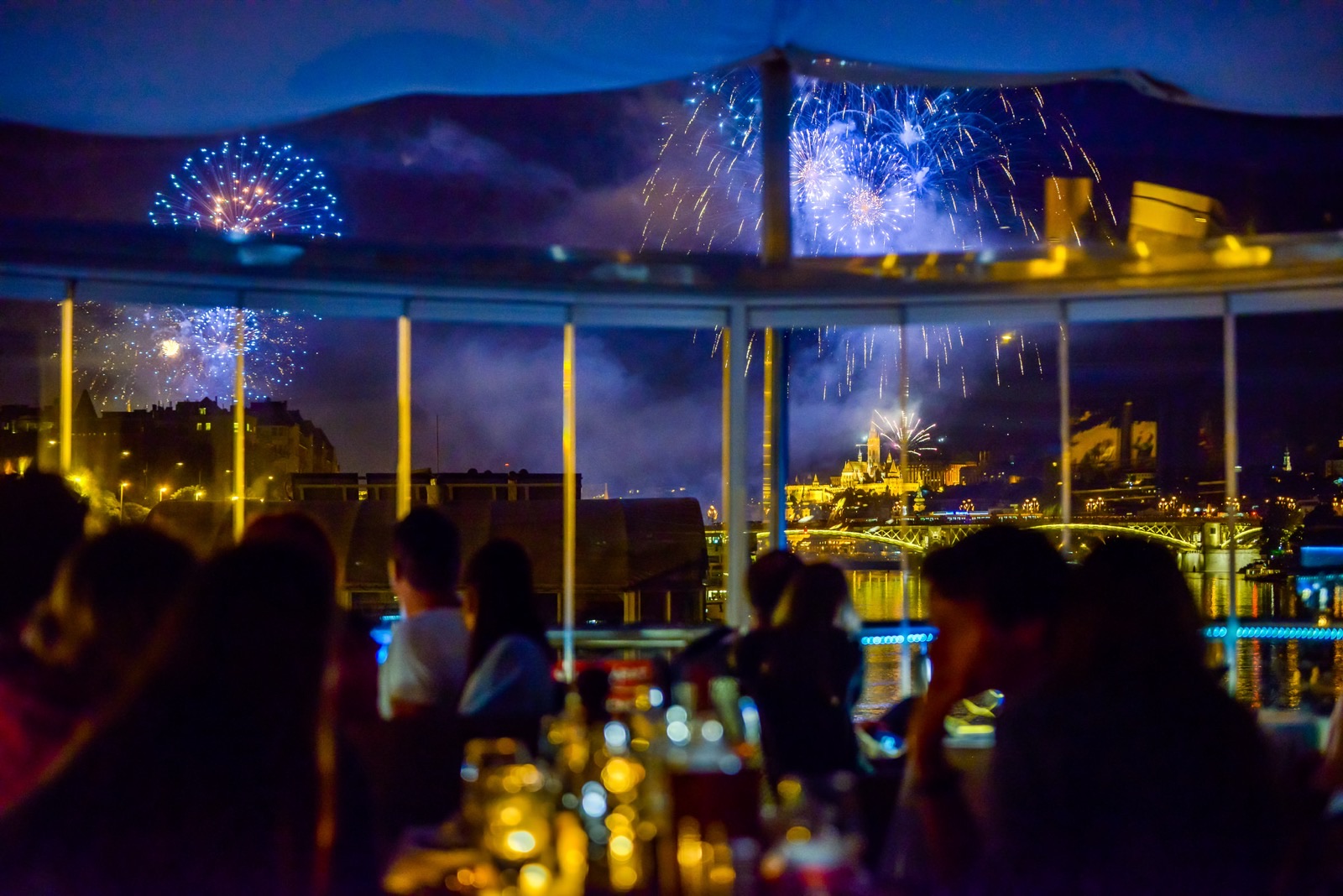 Blue fireworks over the Danube, guests watching from on board